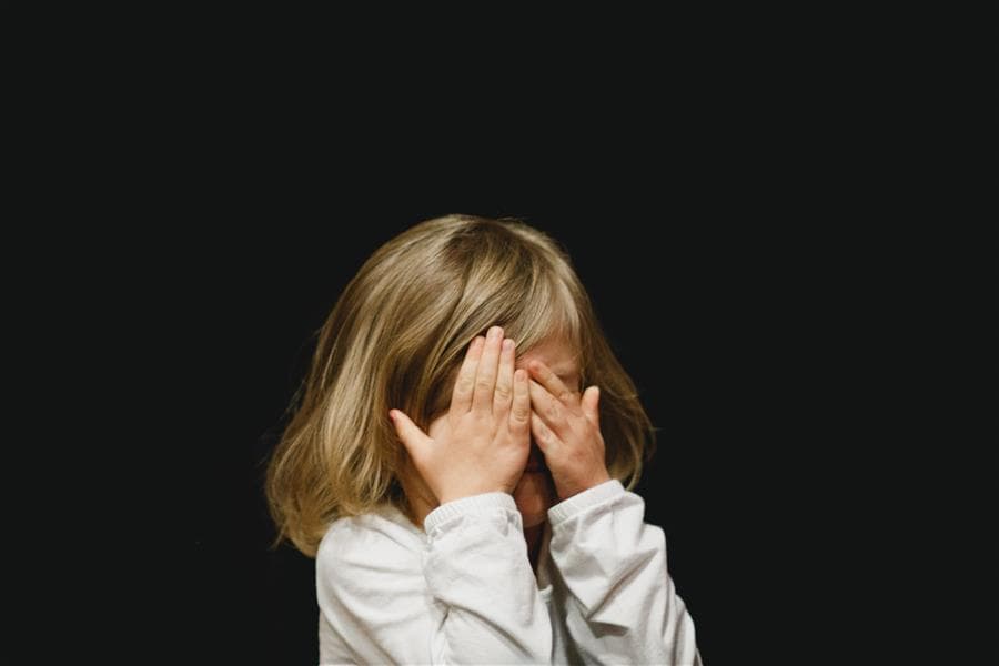 A child laughing while filming a family scene