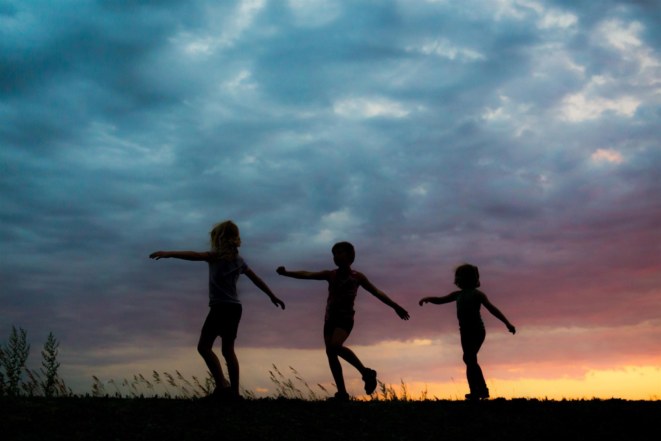 Children playing together outdoors at dusk