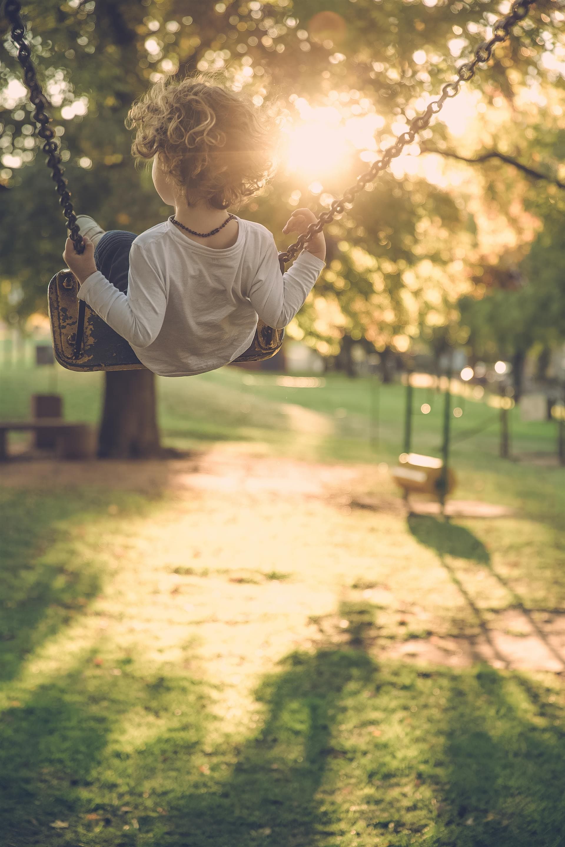 A child swinging through warm evening light