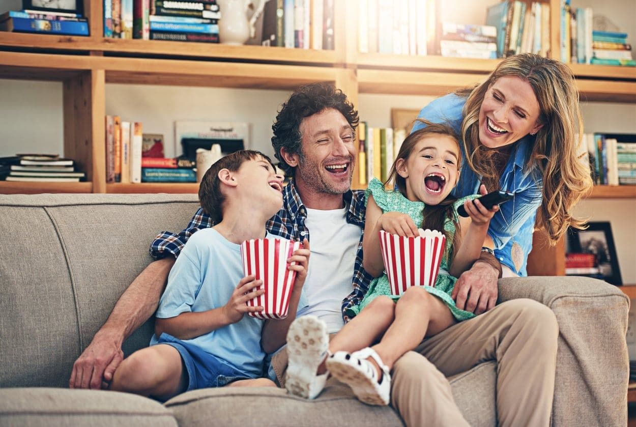 A family laughing together during a home movie premiere